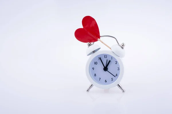 Reloj despertador de color blanco y forma de corazón rojo —  Fotos de Stock