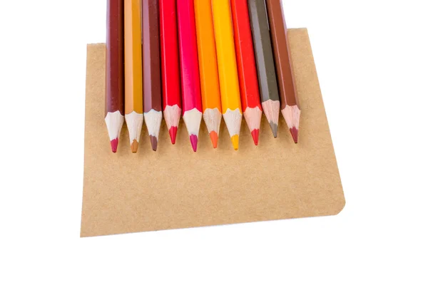 Кольорові олівці на коричневому аркуші паперу — стокове фото