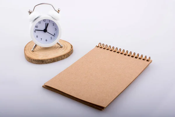 Cuaderno espiral y reloj despertador — Foto de Stock