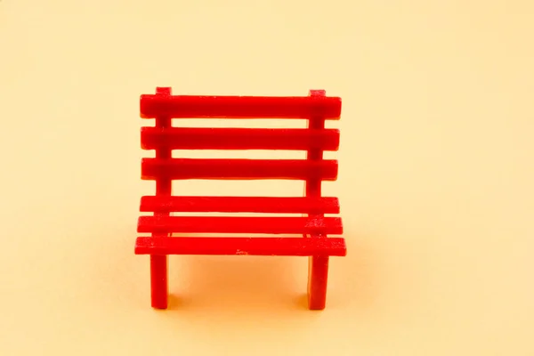 Маленька червона мініатюрна лавка з пластику — стокове фото