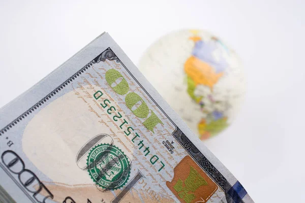 Billetes en dólares americanos al lado de un globo modelo — Foto de Stock
