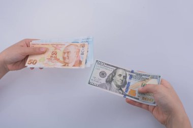 Amerikan Doları banknot ve Turksh Lirası banknot beyaz arka plan üzerinde yan yana holding eller