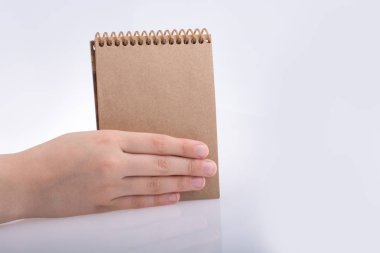 Kahverengi renk defter tutan el 