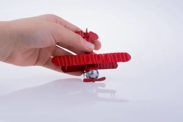 Mão segurando um avião de brinquedo em um fundo branco — Fotografia de Stock