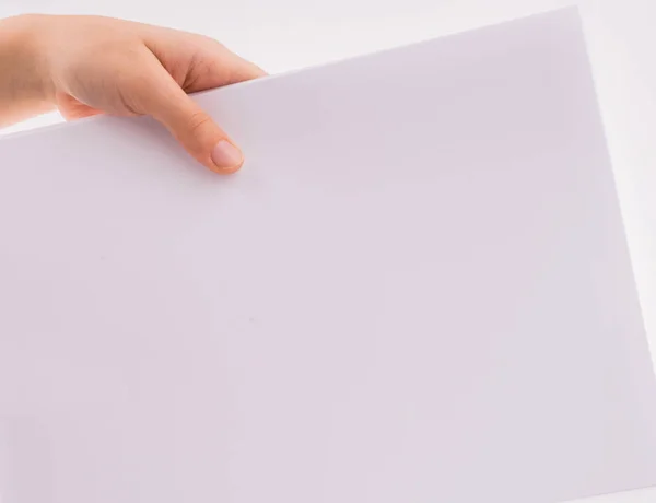 Рука держит белый чистый лист бумаги — стоковое фото