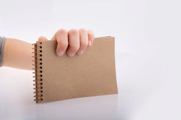 Χέρι που κρατά ένα σημειωματάριο καφέ χρώμα — Φωτογραφία Αρχείου
