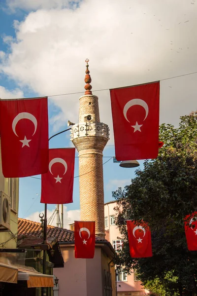 Turkish national flag hang on a rope in the street with a minare — Stock Photo, Image