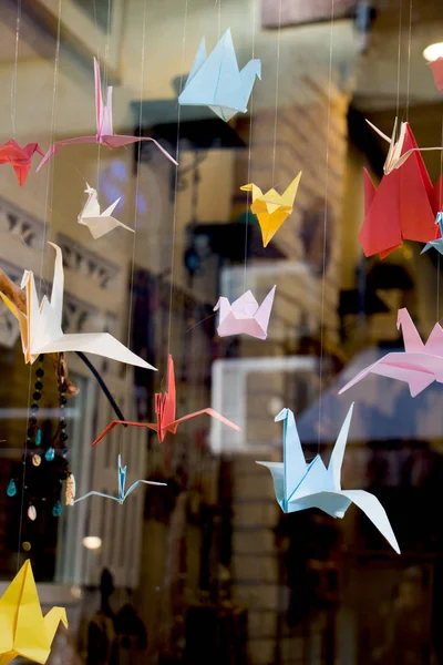 Colorful paper origami birds tied to strings