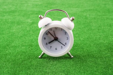 Çalar saat yeşil çim zemin üzerine