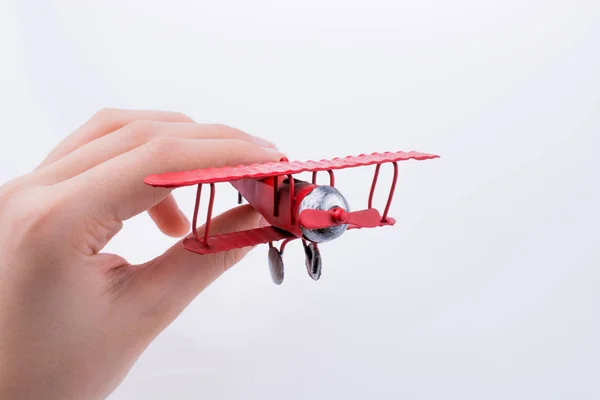 Mano sosteniendo un avión de juguete sobre un fondo blanco — Foto de Stock