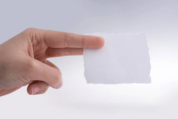 Ręka trzyma kawałek rozdarty papier — Zdjęcie stockowe