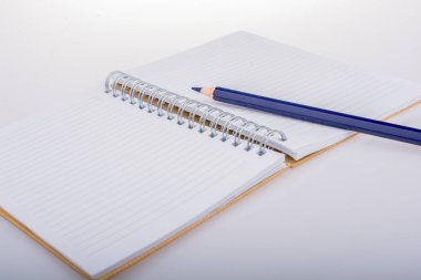 Boş bir defter üzerinde yerleştirilen renkli kalem