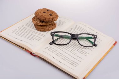 Çikolatalı kurabiye ve gözlük bir kitap üzerine