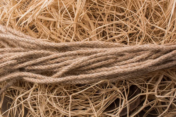 Pacote de corda de linho em fundo de palha — Fotografia de Stock
