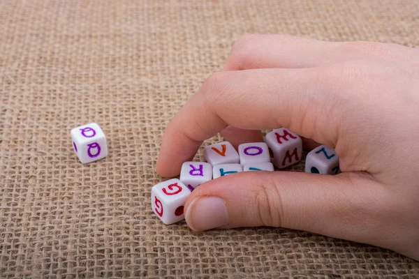 Cubos de letra alfabeto colorido na mão — Fotografia de Stock
