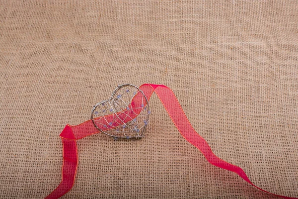 Fascia e gabbia a forma di cuore su tela di lino — Foto Stock