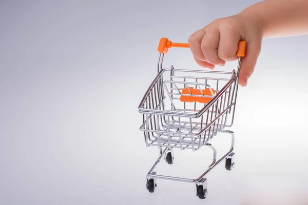 Carrinho de compras a mão no fundo branco — Fotografia de Stock