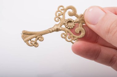 Bir retro tarzı altın renk anahtarı tutan çocuk el 