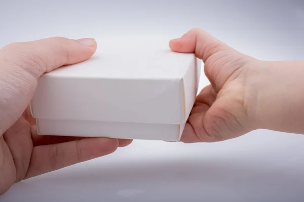 Mão dando caixa de presente branco para fora — Fotografia de Stock