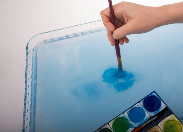 Pintura disolviéndose como pincel de pintura toca el agua —  Fotos de Stock