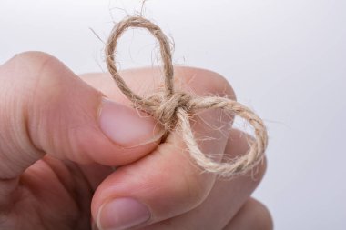 İplik düğüm açık renk arka plan üzerinde elinde