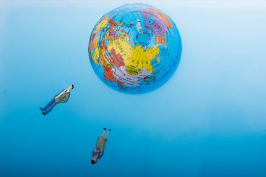 Küçük dünya etrafında yüzen figürler ile