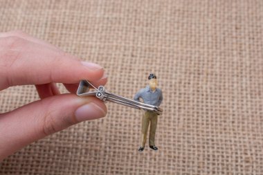 Adam heykelcik keten tuval arka plan üzerinde elinde