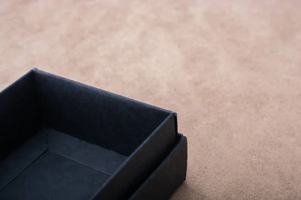 Чорна подарункова коробка на коричневому фоні — стокове фото