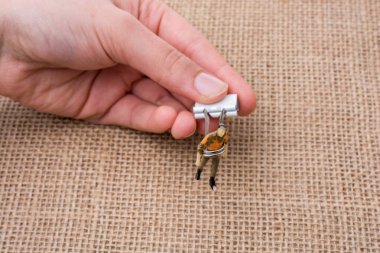 Adam heykelcik keten tuval arka plan üzerinde elinde