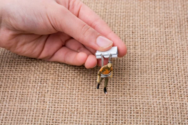 Adam heykelcik keten tuval arka plan üzerinde elinde