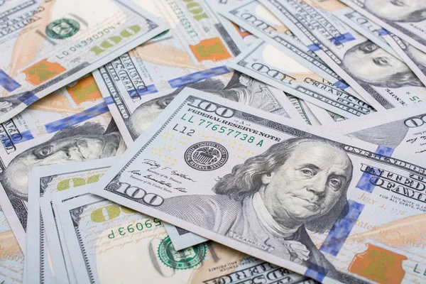 Катушка льняной катушки размещена на разбросанных банкнотах доллара США — стоковое фото