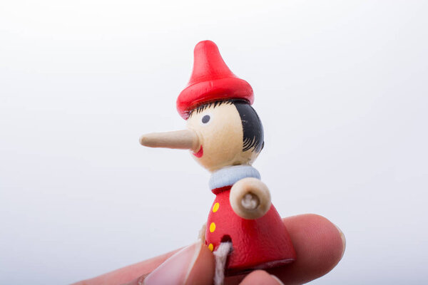 woman hand with Pinocchio on white background