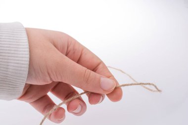 Kahverengi renk keten iş parçacığı elinde tutan el