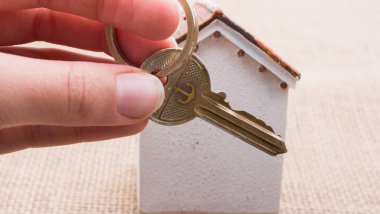 Bir anahtar tarafından bir modeli ev tutan el 