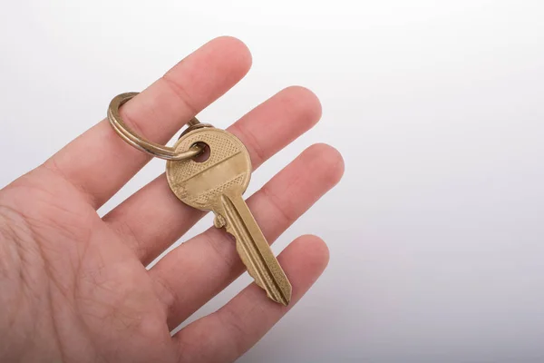Hand holding a  golden color key — Stock Photo, Image