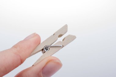 Küçük bir ahşap clothespin tutan el 