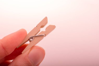 Küçük bir ahşap clothespin tutan el 