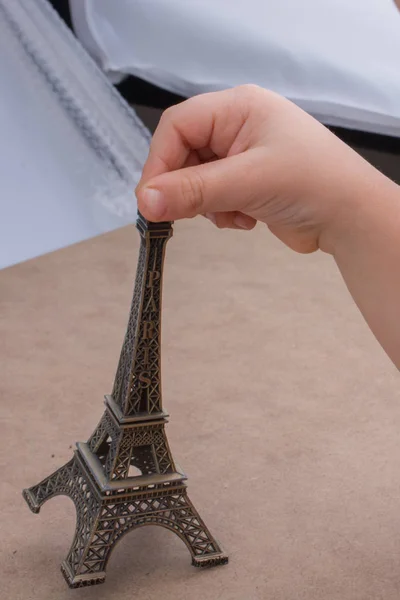 Kind hält das kleine Modell des Eiffelturms in der Hand — Stockfoto