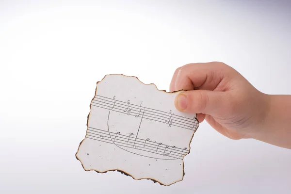 Hand Holding Burnt Paper Musical — Stock Photo, Image