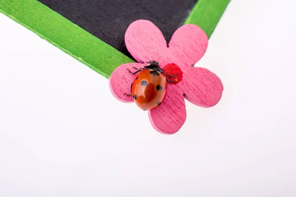 Beautiful red ladybug walking on a fake flower — Stock Photo, Image