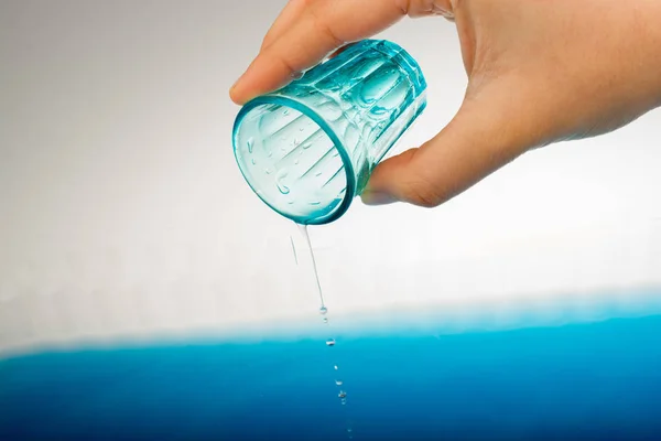 Voda stéká ze skla v ruce — Stock fotografie