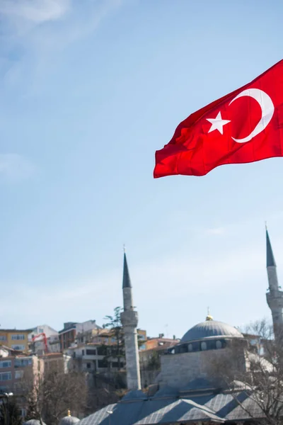 Turkish national flag hang on a rope in the street with a minare — Stock Photo, Image