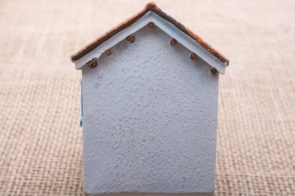 Malý model dům na hnědé pozadí — Stock fotografie