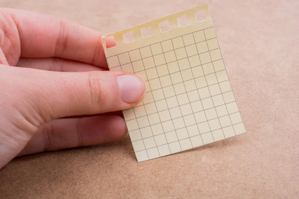 Mão segurando um papel de nota na mão — Fotografia de Stock