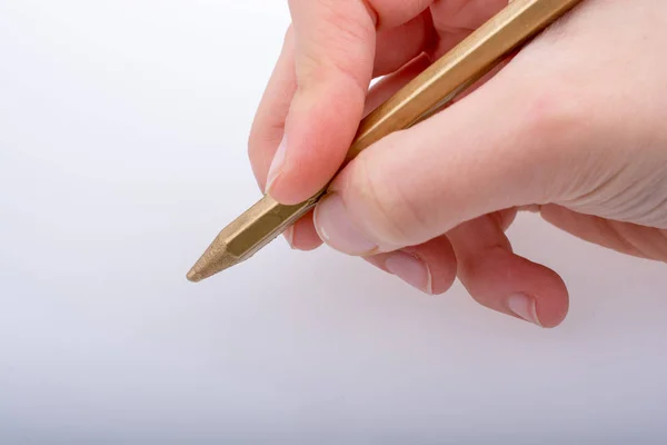 Hand holding a gold color pencil  in hand Stock Picture