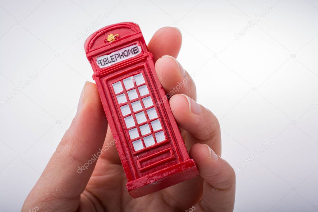  Hand holding a phone booth on a white background