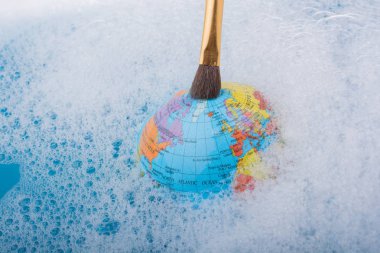 Dünya üstüne yerleştirilen boya fırçası