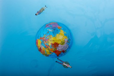 Küçük dünya etrafında yüzen figürler ile