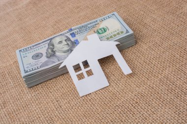 Kağıt ev Amerikan dolarlarının üzerine yerleştirilmiş.