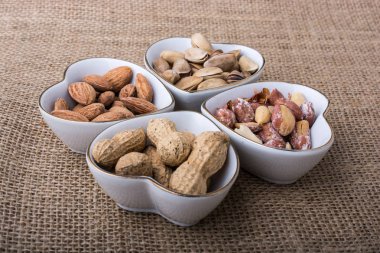 Tuval üzerinde kalp şeklinde tabaklar içinde fındık 